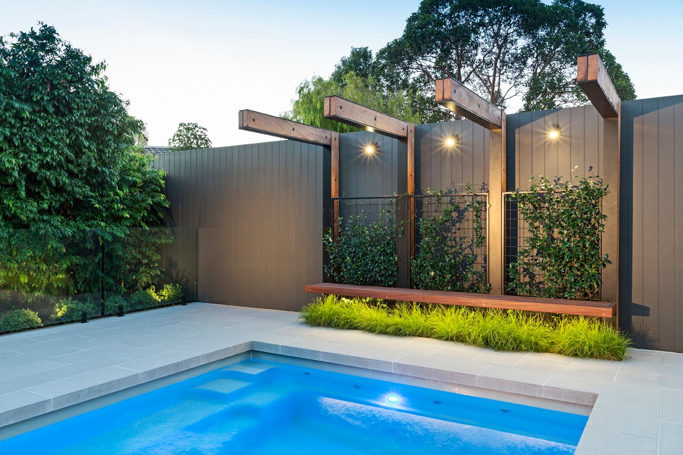 Poolside custom designed bench and arbour with soft plantings.