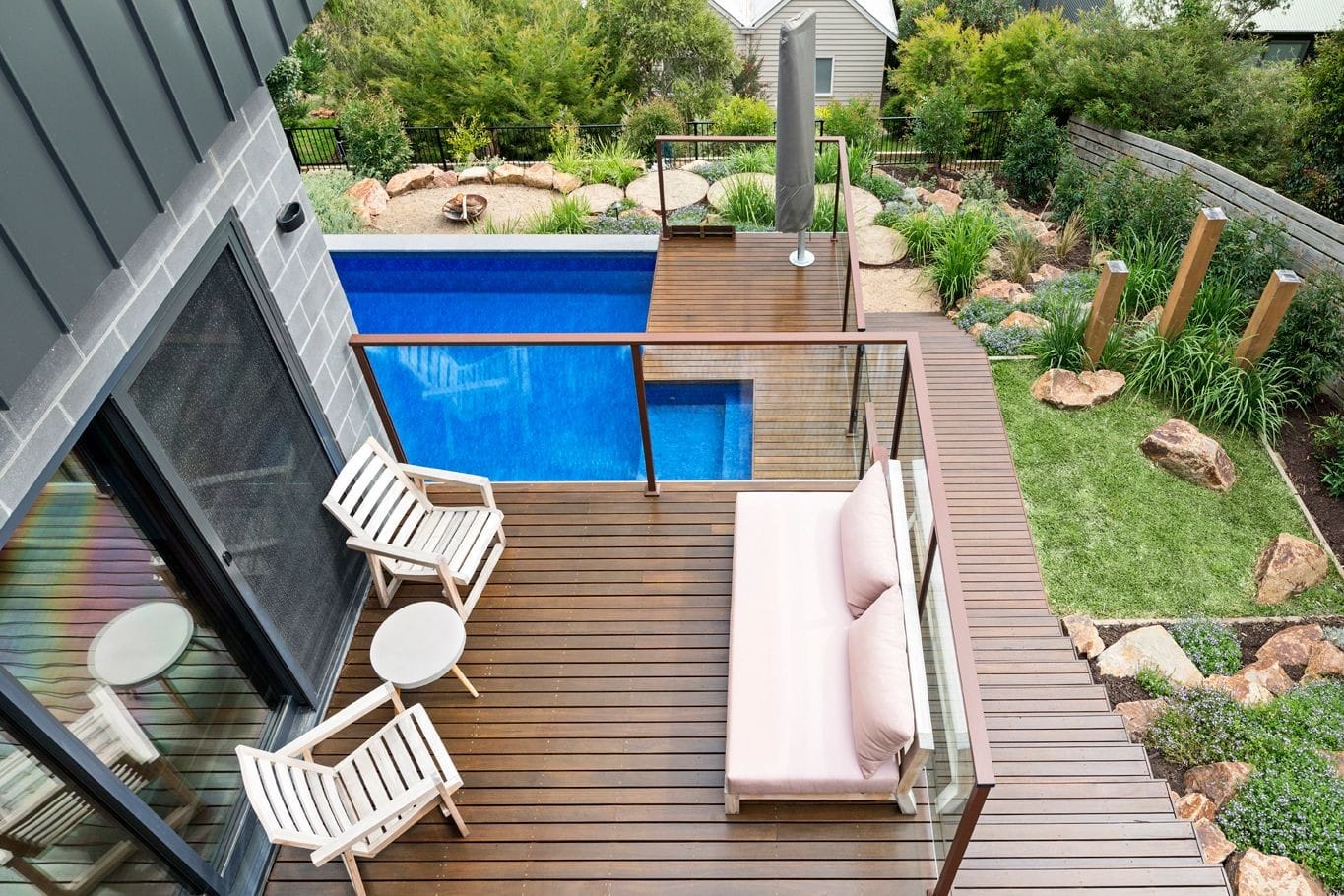 Natural timber decking brings warmth to this coastal garden and pool