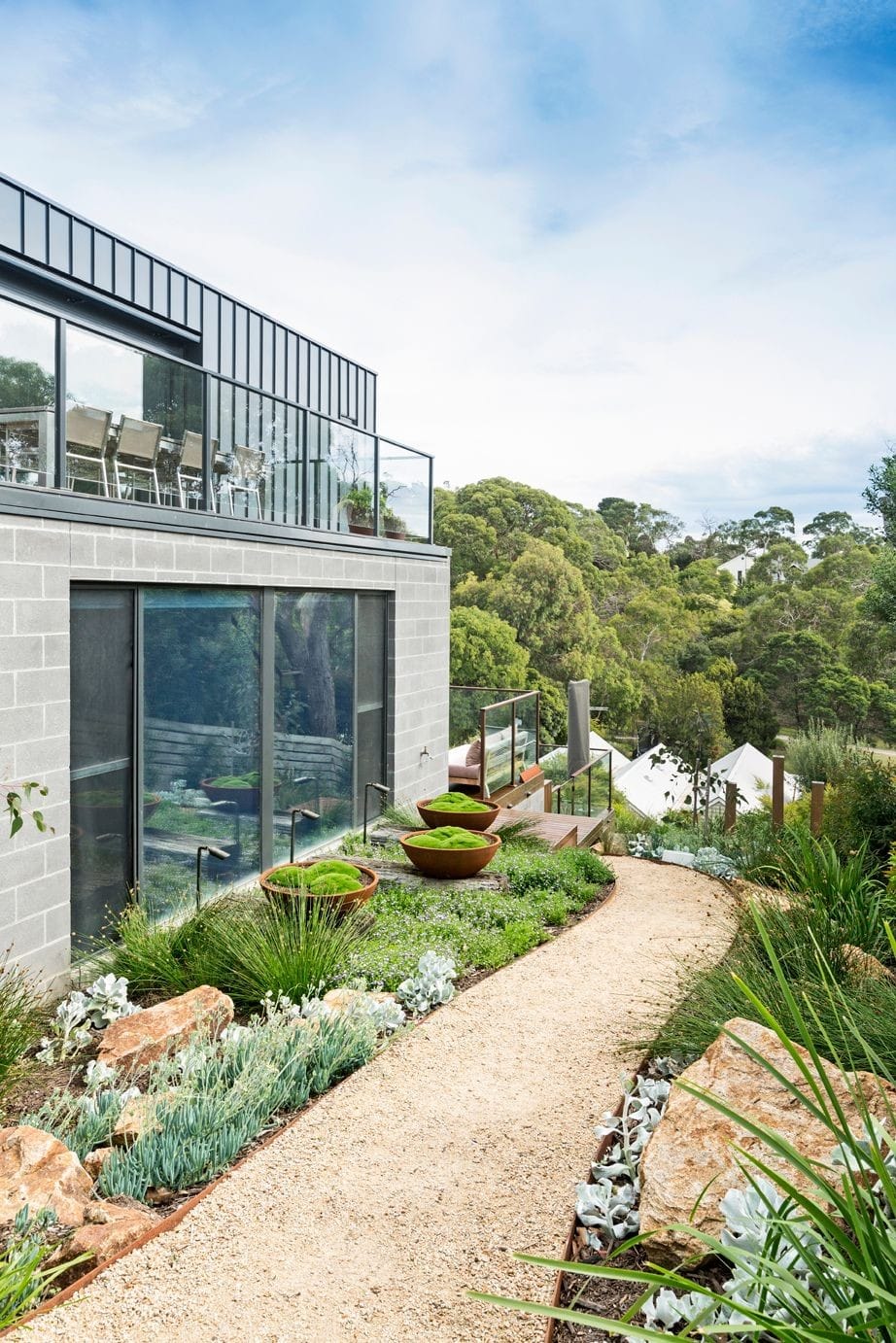 the use of bowls and coastal native plantings, rust and rocks make this coastal landscape design modern